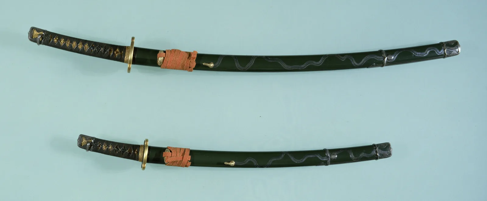 Pareja de daishō en montura handachi, laca verde con un dibujo de corriente de agua en plata.