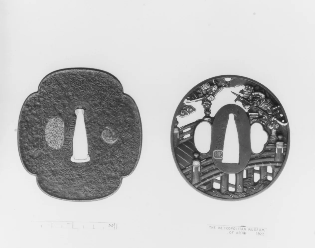 Dos tsuba de hierro en una lámina de estudio: uno liso de forma mokko, otro calado con una escena de guerreros junto a un puente.