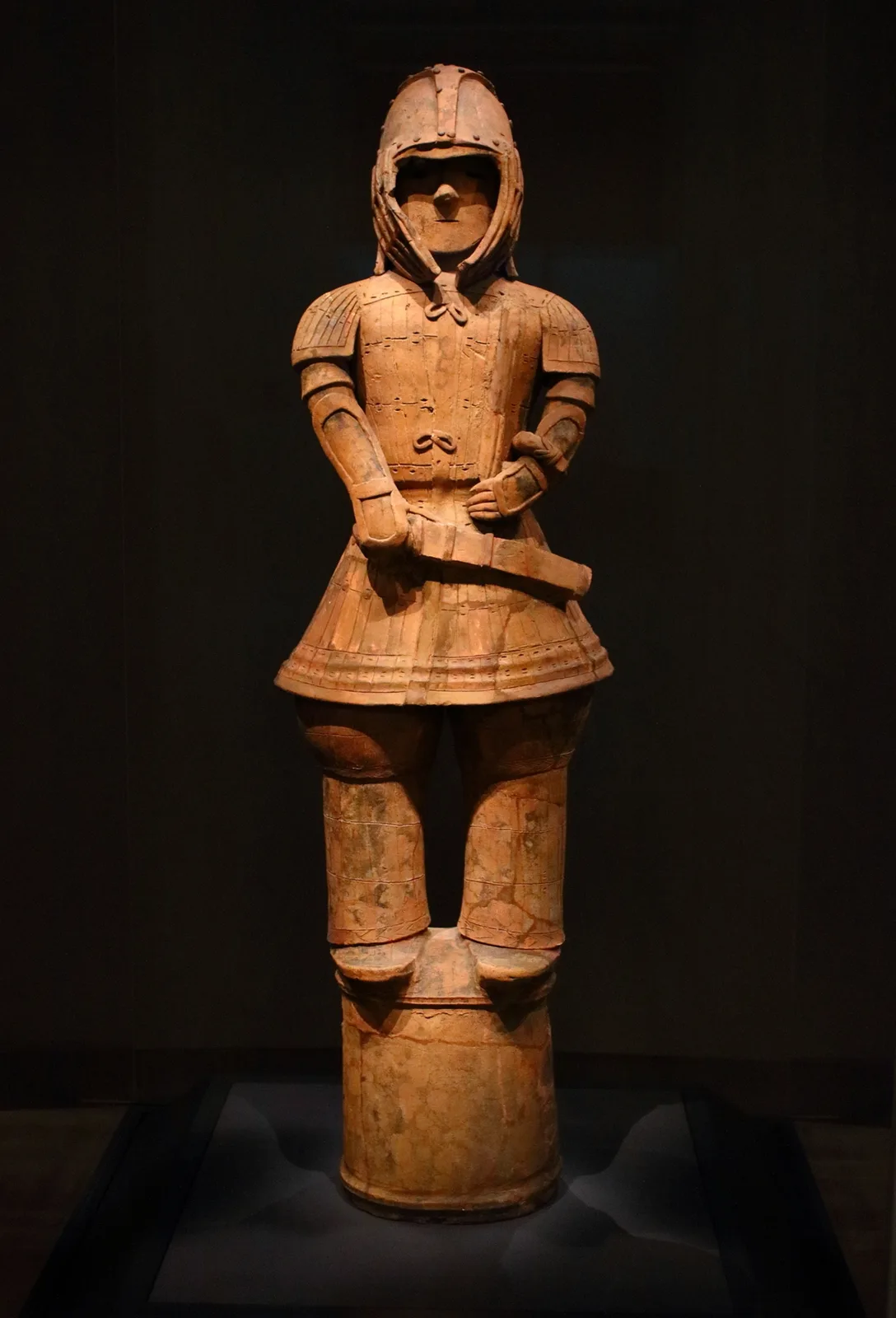 Haniwa de terracota que representa a un guerrero del periodo Kofun con armadura laminar keikō, casco y una espada recta al costado.
